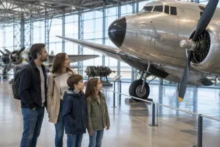 Famille de quatre personnes observant un avion historique dans un hall du Musée de l’Air et de l’Espace du Bourget.
